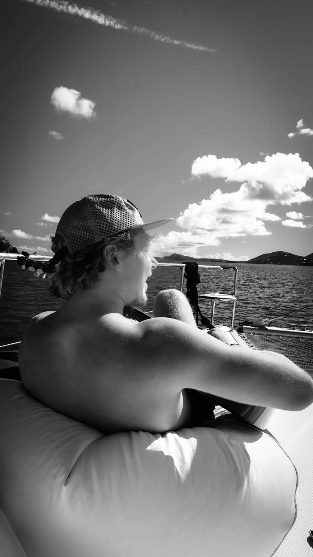Guest playing guitar on the bow trampoline of Stella Blue, USVI — black and white