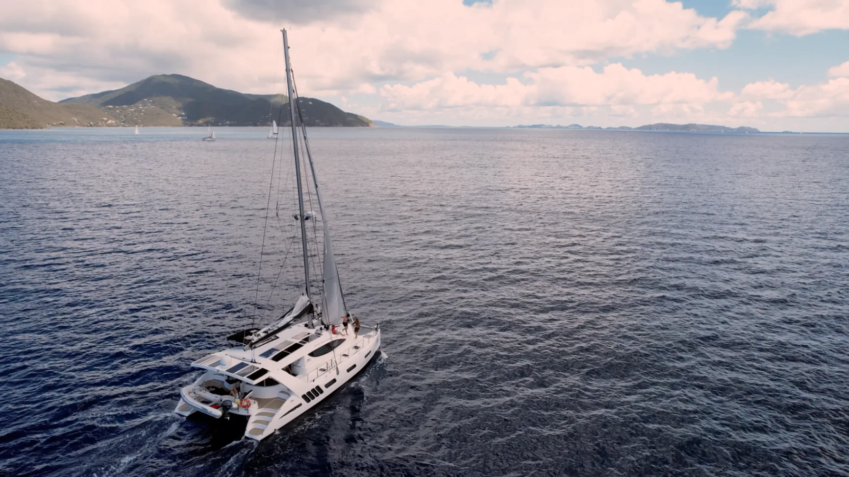 Aerial sunset-toned view of Stella Blue sailing through open Caribbean water in the Virgin Islands
