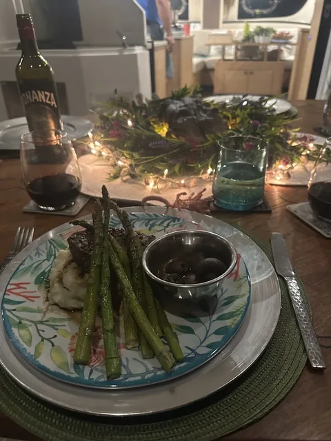 Candlelit dinner aboard Stella Blue — seared steak, asparagus, mashed potatoes and red wine at the salon table