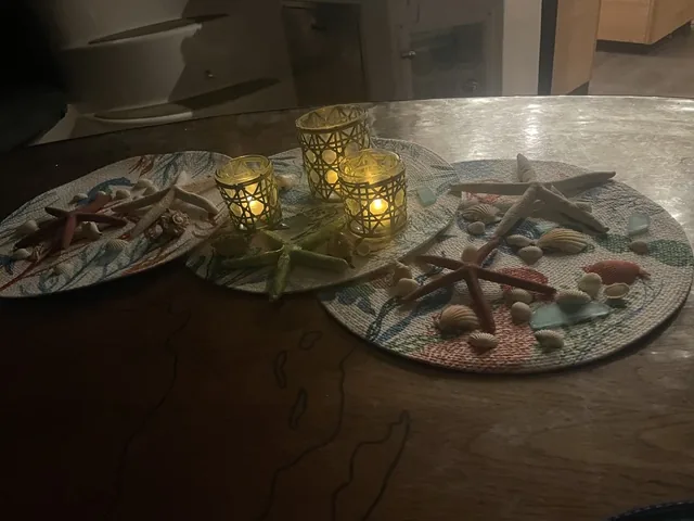 Candlelit table aboard Stella Blue set with starfish, seashells and sea glass for a coastal-themed dinner