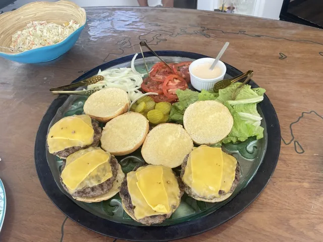 Platter of fresh-grilled cheeseburger sliders with coleslaw, pickles, tomato and lettuce served aboard Stella Blue