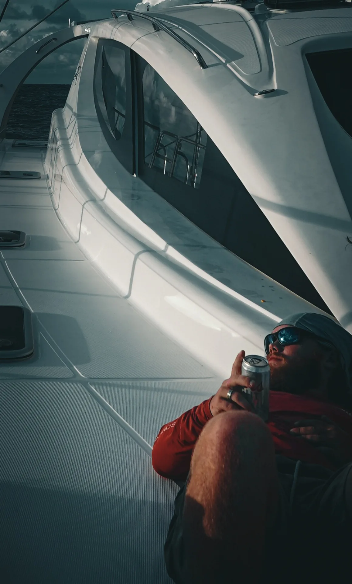 Guest relaxing on the foredeck of Stella Blue with a cold drink, Virgin Islands