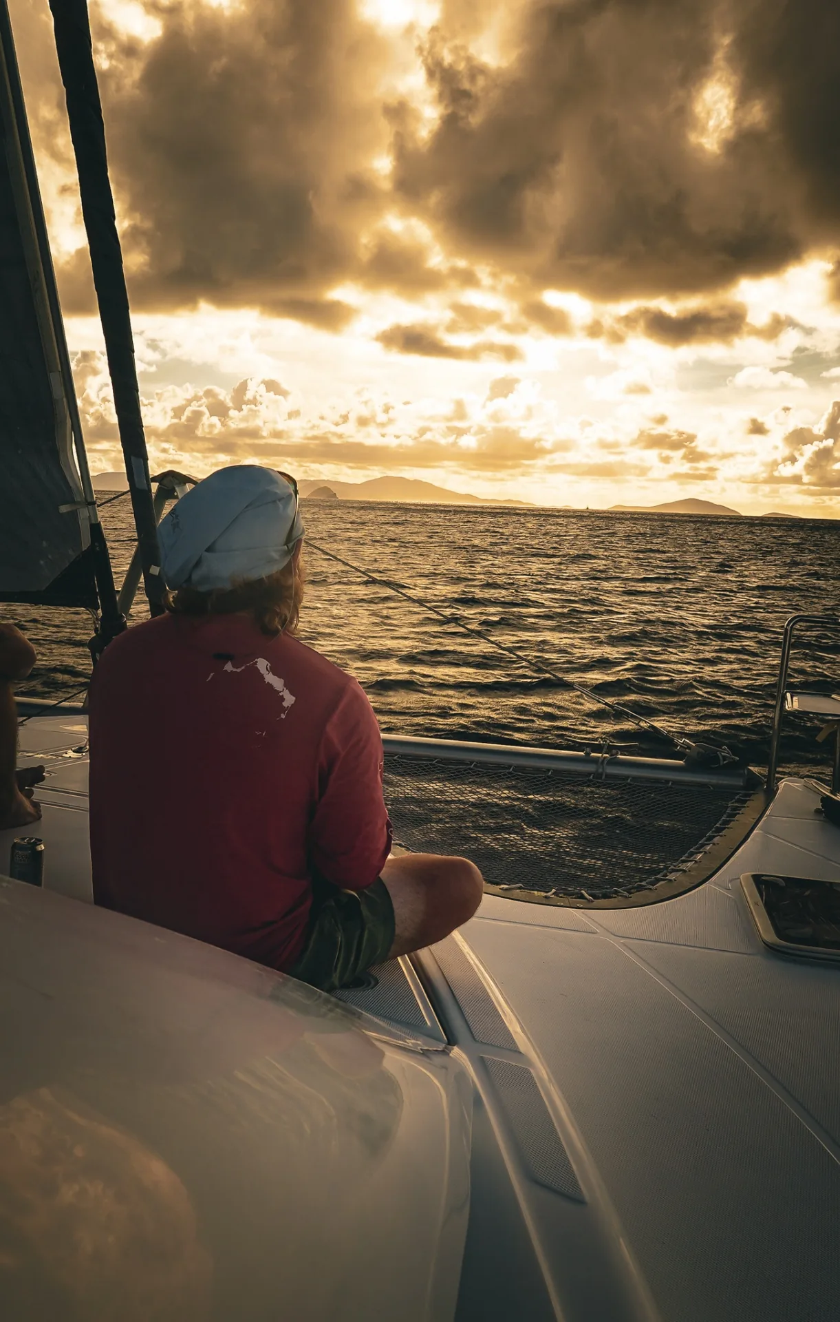 Guest watching the sunset from the bow of Stella Blue near St. John