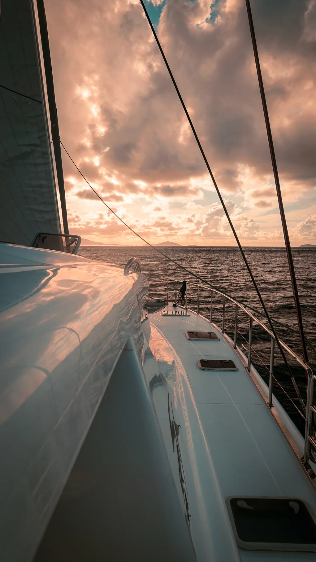 Side deck of Stella Blue catamaran sailing into a golden Caribbean sunset
