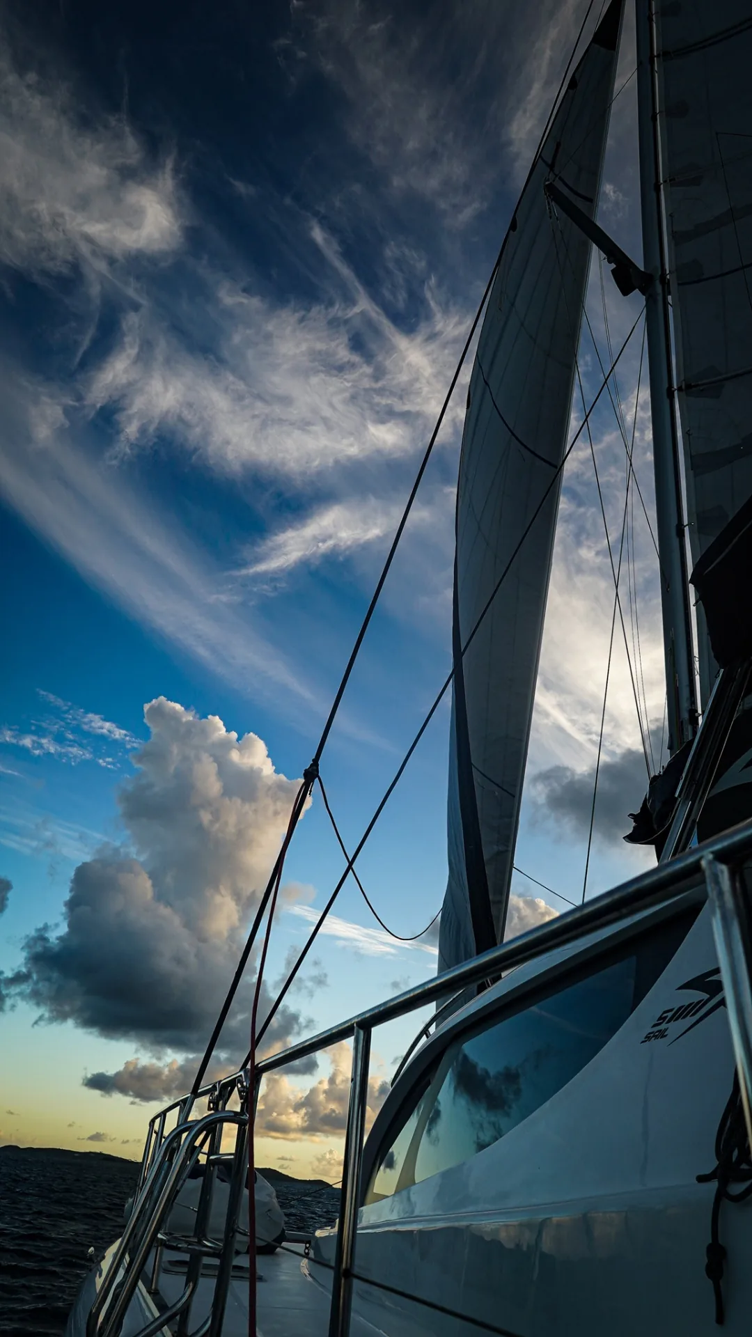 Mainsail and headsail set against blue Virgin Islands sky from the side deck of Stella Blue
